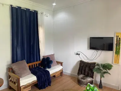 a living room with a tv and a chair at Kishongo house in Arusha