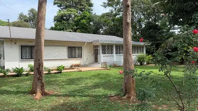 a white house with trees in the yard at Malaika Oasis in Moshi