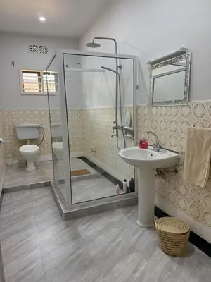 a bathroom with a shower and a sink and a toilet at Malaika Oasis in Moshi