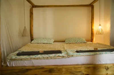 a bed with two pillows on it in a room at Hakuna in Arusha