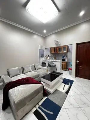 a living room with a couch and a table at Hadraj Clocktower Apartment1 in Arusha