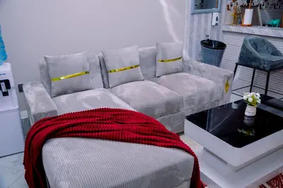 a living room with a couch with a red blanket at Hadraj Clocktower Apartment1 in Arusha