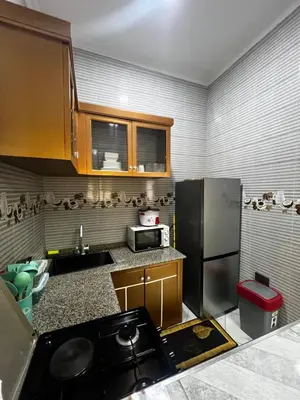 a kitchen with a stove and a refrigerator at Hadraj Clocktower Apartment1 in Arusha