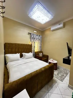 a bedroom with a large bed and a couch at Hadraj Clocktower Studio Apt in Arusha