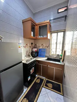 a small kitchen with a refrigerator and a stove at Hadraj Clocktower Studio Apt in Arusha