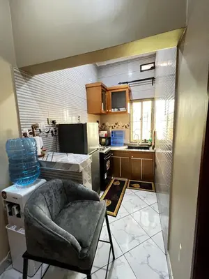 a small kitchen with a chair in a room at Hadraj Clocktower Studio Apt in Arusha
