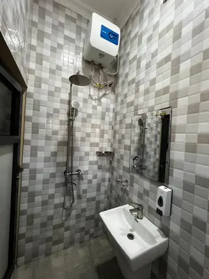 a bathroom with a white sink and a shower at Hadraj Clocktower Studio Apt in Arusha