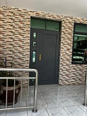 a black door on the side of a brick building at Hadraj Clocktower Studio Apt in Arusha