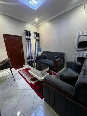 a living room with a couch and a table at Hadraj Clocktower Apartment2 in Arusha