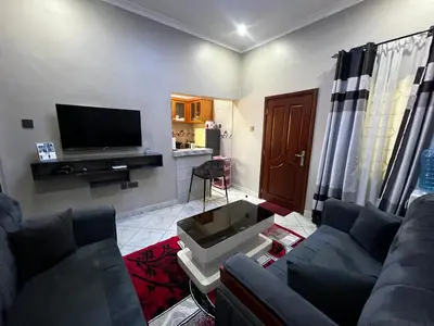 a living room with two couches and a flat screen tv at Hadraj Clocktower Apartment2 in Arusha