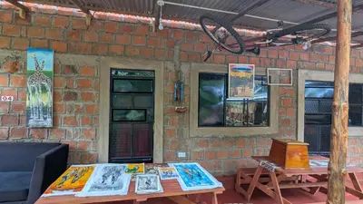 a brick wall with a table with paintings on it at Alkebulan Farm House in Moshi