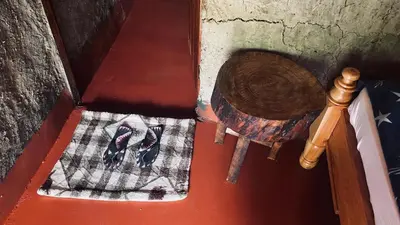 an open door with a pair of shoes on a rug at Alkebulan Farm House in Moshi