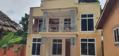 a house with a balcony on the side of it at Hopeland Villas in Msaranga