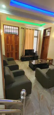 a living room with a couch and a piano at Hopeland Villas in Msaranga