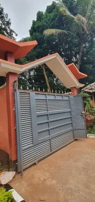 a garage door with a gate in front of a house at Hopeland Villas in Msaranga