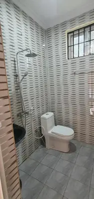 a bathroom with a toilet and a shower at Hopeland Villas in Msaranga