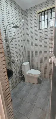 a bathroom with a toilet and a shower at Hopeland Villas in Msaranga