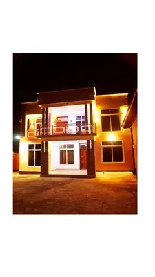 a house with a balcony at night with lights at Hopeland Villas in Msaranga