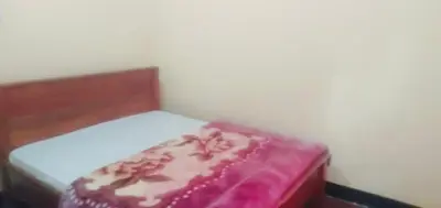 a small bed with a pink blanket on it at Home sweet home in Uru