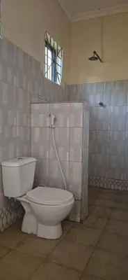 a bathroom with a white toilet and a window at Eagle Nest lake Natron Lodge in Mtowabaga