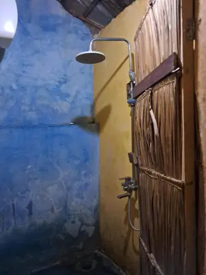 a bathroom with a painting on the wall at Ibrahim Garden Hostel in Arusha