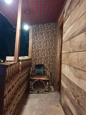 a chair sitting on the balcony of a house at Ibrahim Garden Hostel in Arusha