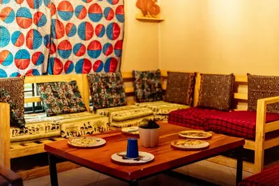 a living room with couches and a table with plates on it at Kilimanjarosons homestay in Moshi
