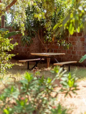 two picnic tables in front of a brick wall at Kilimanjarosons homestay in Moshi