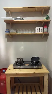 a stove top oven sitting on top of a wooden table at Kilimanjarosons homestay in Moshi