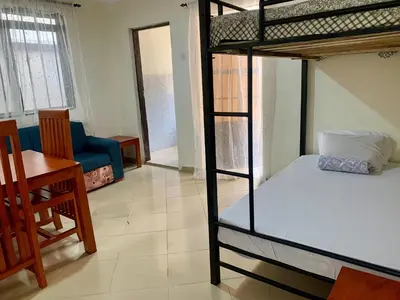 a room with two bunk beds and a dining room at Amani Homestay in Arusha