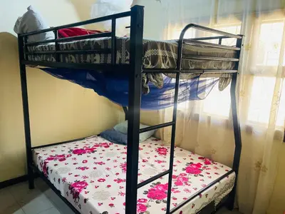 two bunk beds in a room with a floral mattress at Amani Homestay in Arusha