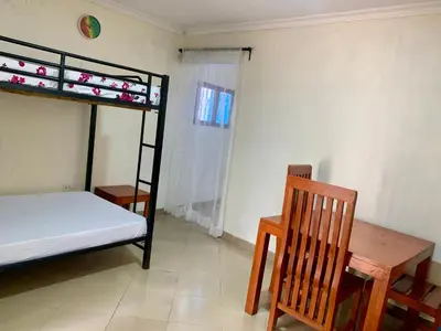 a bedroom with a bunk bed and a wooden table at Amani Homestay in Arusha