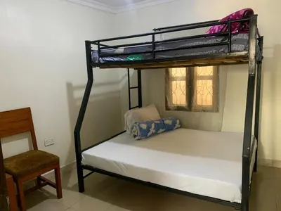 a bedroom with a bunk bed and a chair at Amani Homestay in Arusha