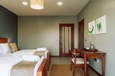 a bedroom with two beds and a desk and a table at The Scenery Residence in Arusha