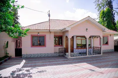 a small white house with a brick driveway at Hadraj Moshono Apartment1 in Arusha
