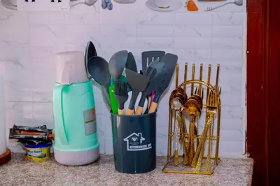 a black container filled with utensils on a counter at Hadraj Moshono Apartment1 in Arusha
