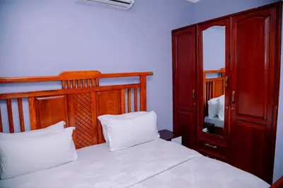 a bedroom with a bed and a red cabinet at Hadraj Moshono Apartment1 in Arusha