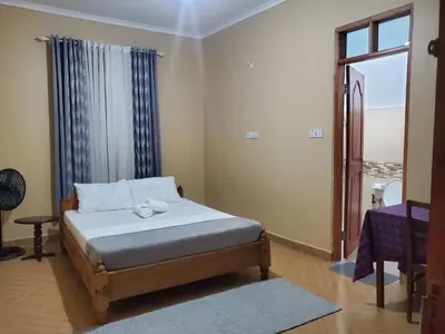 a bedroom with a bed and a window at Shilling Stay in Moshi