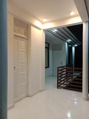 a hallway with a white door and a staircase at Hidalgo Home Apartment's in Moshi