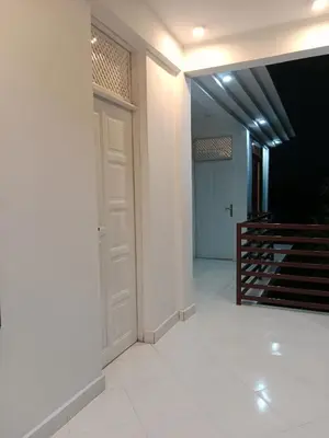 a hallway with a white door and a staircase at Hidalgo Home Apartment's in Moshi