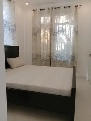a bed in a room with a large window at Hidalgo Home Apartment's in Moshi