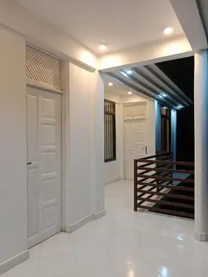 a hallway with two white doors and a staircase at Hidalgo Home Apartment's in Moshi