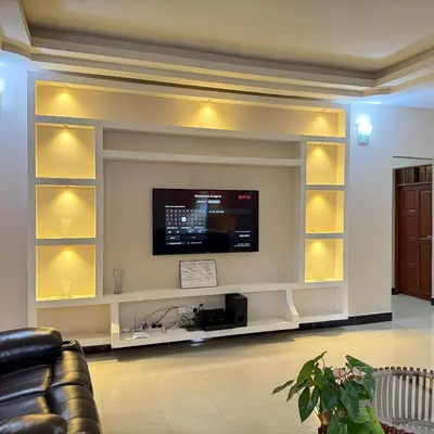 a living room with a flat screen tv on a wall at Mercy Apartments Moshi in Uru