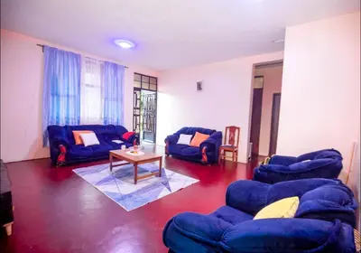 a living room with blue couches and a table at New Star House in Arusha