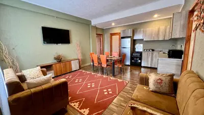 a living room with a couch and a dining room at Lush Garden Apartment in Arusha