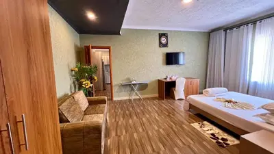 a living room with a bed and a couch in a room at Lush Garden Apartment in Arusha