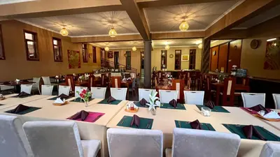 a large table in a room with chairs at Lush Garden Apartment in Arusha