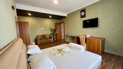 a living room with a couch and a tv at Lush Garden Apartment in Arusha