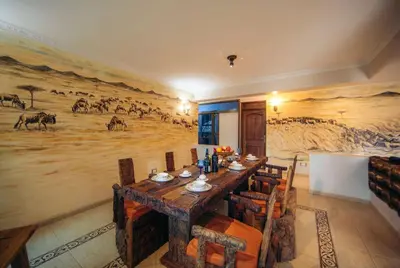 a dining room with a large painting on the wall at Gafa House lodge in Sokon