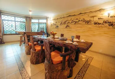 a dining room with a large painting on the wall at Gafa House lodge in Sokon